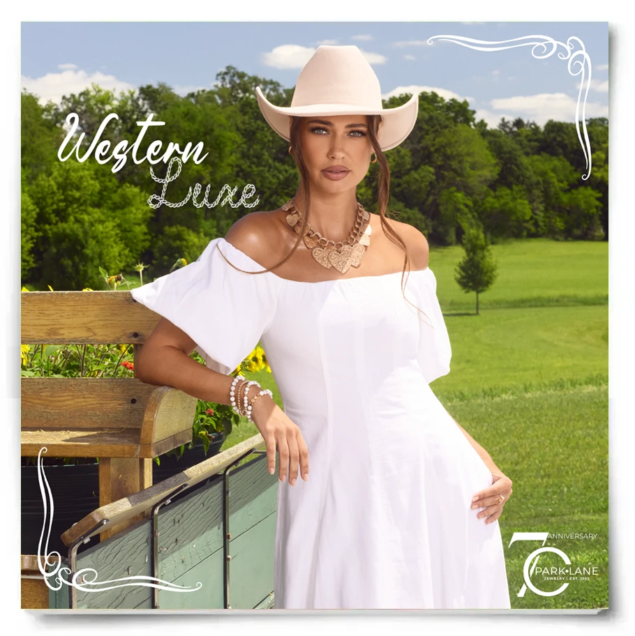 Model in a white dress with a cowboy hat on, leaning on a wodden fence