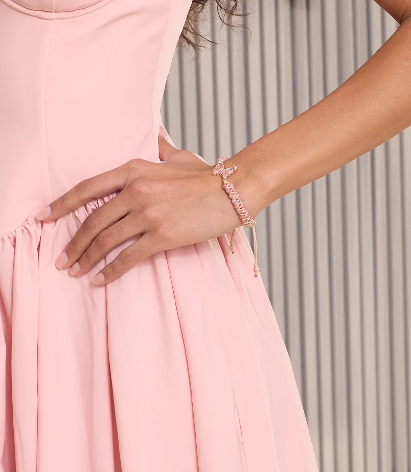 Model in pink dress wearing pink bracelet