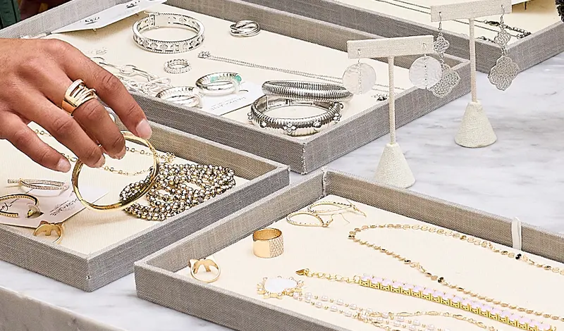 Overhead look at trays of silver adn gold jewelry