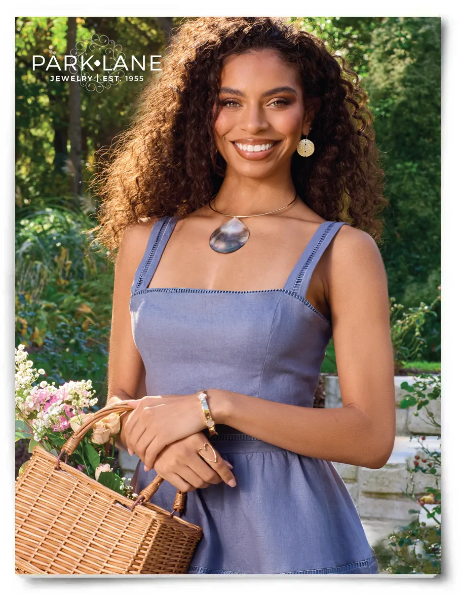 Model wearing a blue dress with a large necklace piece, heart ring and golden bracelet